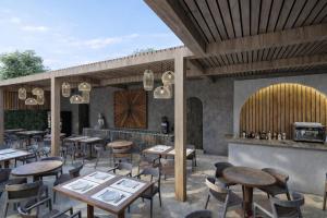a restaurant with wooden tables and chairs and a bar at Carpe Diem Hotel in Borsh