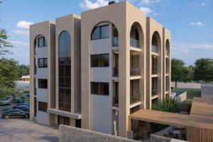 a building with arched windows and a parking lot at Carpe Diem Hotel in Borsh