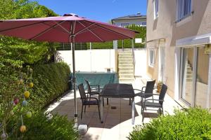 a patio with a table and chairs and an umbrella at Ferienwohnung im Goldtal in Bad Abbach