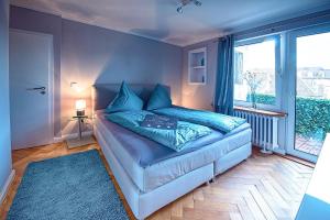a bedroom with a bed with blue sheets and a window at Holiday Trier City in Trier