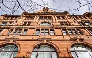 a large brick building with windows on the side of it at Heathcote Hotel Manchester in Manchester