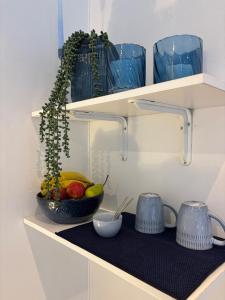 a shelf with a bowl of fruit and blue glasses at Cottage in Ballito in Ballito +11 photos