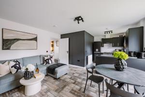 a living room with a couch and a table at SmartSleep Apartments in Glasgow +21 photos