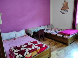 a room with two beds and a table in it at Nima homestay in Dirang Dzong +2 photos