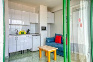 a living room with a blue couch and a table at RT-Green Park in Playa del Ingles