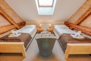 two twin beds in a room with a window at Penzion Vila Machů in Kopřivnice