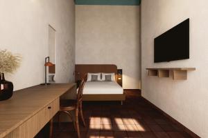 a bedroom with a bed and a desk with a television at BYPILLOW Del Presto in Florence