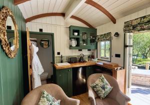 a kitchen with green cabinets and a counter top at Melbury Hut in Shaftesbury +23 photos