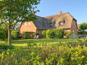 a large brick house with a thatched roof at Reethus Hans in Husum