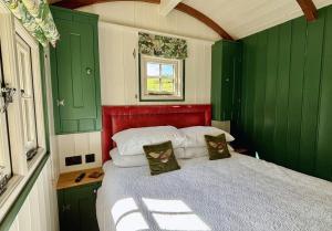 a small bedroom with green cabinets and a bed at Melbury Hut in Shaftesbury