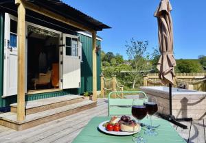 a table with a plate of food and two glasses of wine at Melbury Hut in Shaftesbury