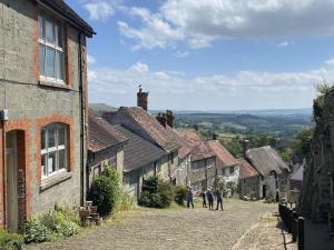a group of people walking down a cobblestone street at Melbury Hut in Shaftesbury