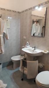 a bathroom with a sink and a toilet and a mirror at Affittacamere Da Priscilla in Porto Torres +18 photos