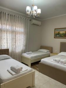 a bedroom with two beds and a chandelier at Unejs Apartment in Berat