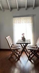 two chairs and a table in a room with a window at Romanou Guest House in Romanón