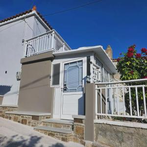 a white house with stairs and a balcony at Romanou Guest House in Romanón