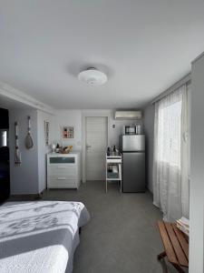 a white room with a bed and a kitchen at Romanou Guest House in Romanón