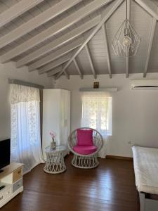 a living room with a pink chair and a table at Romanou Guest House in Romanón