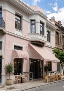 a pink building with a table outside of it at Orchard in Athens