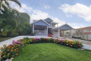 a house with a flower garden in front of it at Emerald Bleu Villa in Gros Islet