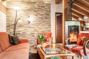 a living room with a couch and a fireplace at Chalet Hinter dem Rot Stei, private wellness, in ski and hiking area of Zermatt in Zermatt