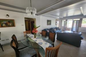 a dining room and living room with a glass table at Emerald Bleu Villa in Gros Islet