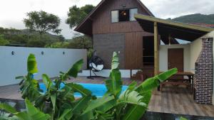 a house with a swimming pool in front of it at Recanto Deucher in Imaruí