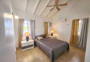 a bedroom with a bed and a ceiling fan at Emerald Bleu Villa in Gros Islet
