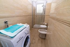 a bathroom with a washing machine and a toilet at Appartamenti Procchio Onda e Marina - Tesi Viaggi in Procchio +47 photos