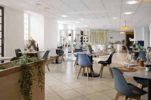 a restaurant with tables and chairs in a room at Hôtel Restaurant Le Commerce in Navarrenx