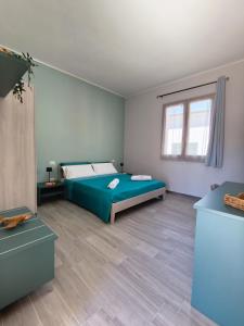 a bedroom with a green bed and a window at B&B Casa Lina in Sarroch