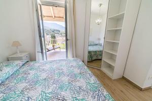 a bedroom with a bed and a door to a balcony at Appartamenti Procchio Onda e Marina - Tesi Viaggi in Procchio