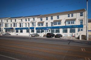 a large white building with cars parked in front of it at Hotel Santa Maria in Blackpool