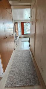 a hallway with a rug in a room with cabinets at Sorvarinraitin sydän in Seinäjoki