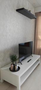 a living room with a tv on a white table at Sorvarinraitin sydän in Seinäjoki +2 photos
