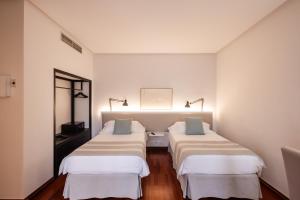 three beds in a room with white walls at Hotel Escuela Santa Brígida in Santa Brígida +35 photos