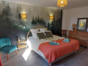 a bedroom with a bed and a blue chair at La Maison d'André in Digny