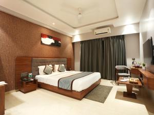 a hotel room with a bed and a desk at Alaukik Hotel in Shirdi +52 photos