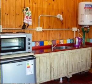 a kitchen with a microwave and a sink at Complejo Bellotas in Agua de Oro