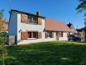 a house with a car parked in front of it at La Maison d'André in Digny