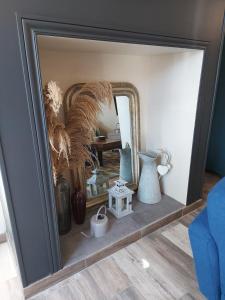 a mirror in a room with vases and a table at La Maison d'André in Digny +25 photos