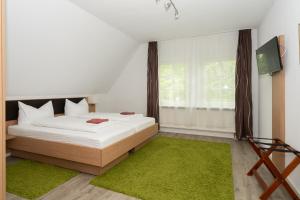 a bedroom with a bed and a green rug at Hotel Garni BURG WALDENSTEIN in Rudersberg