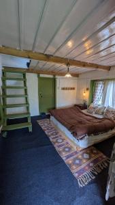 a large bed in a room with a ladder at Finding Clover in Banjār