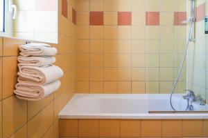 a bathroom with a bath tub and towels at Hôtel Restaurant Le Commerce in Navarrenx +52 photos