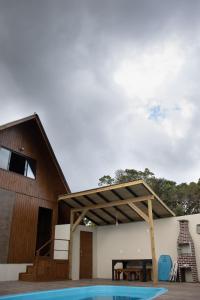 a house with a swimming pool next to a building at Recanto Deucher in Imaruí