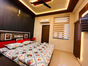 a bed in a bedroom with a ceiling fan at Ophelia in Agra