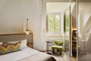 a bedroom with a bed and a green chair at Hôtel & Spa de La Bretesche in Missillac +81 photos