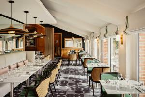 a dining room with tables and chairs and tablesktop at Hôtel & Spa de La Bretesche in Missillac