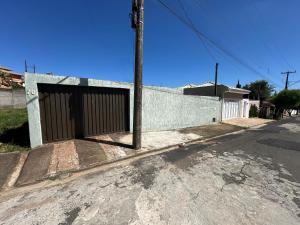 a gate on the side of a wall with a street at Aconchego do Lago in Espirito Santo Do Pinhal