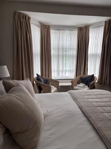 a bedroom with a large white bed and a window at Canterbury Guest House in Sidmouth